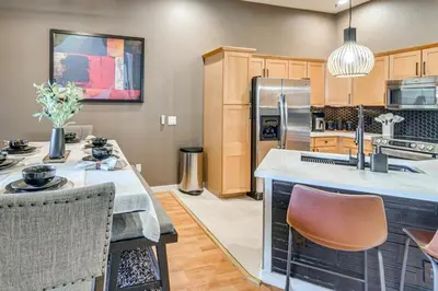 a kitchen with a large island with a counter top at WFH Setup and Garage Parking! Modern Denver Condo in Thornton
