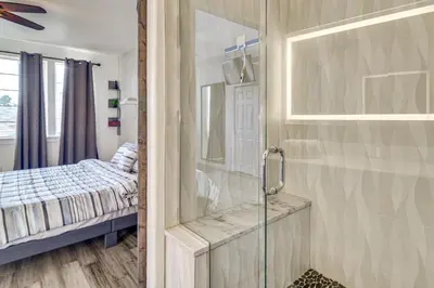 a bathroom with a shower with a glass door at WFH Setup and Garage Parking! Modern Denver Condo in Thornton