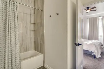 a bathroom with a bath tub and a shower curtain at WFH Setup and Garage Parking! Modern Denver Condo in Thornton