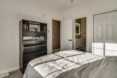 a bedroom with a large bed and a bathroom at WFH Setup and Garage Parking! Modern Denver Condo in Thornton