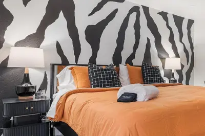 a bedroom with a bed with a zebra mural on the wall at NEW Olde Town Arvada 5BR Luxe Mini Golf Hot Tub Arcade Cinema Gym in Arvada