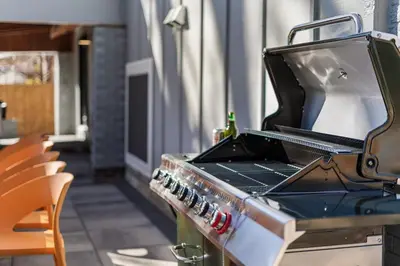 an outdoor grill with a bottle on top of it at NEW Olde Town Arvada 5BR Luxe Mini Golf Hot Tub Arcade Cinema Gym in Arvada