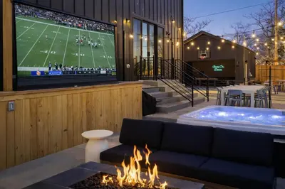 a living room with a tv and a fire pit at Luxury 5BR - Hot Tub - Game Garage - Mini Golf in Denver