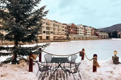 a table and chairs in the snow next to a frozen lake at Lakefront Keystone Escape - Near Slopes & Trails in Keystone