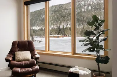 a living room with a chair and a large window at Lakefront Keystone Escape - Near Slopes & Trails in Keystone