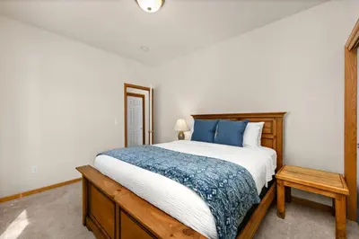 a bedroom with a large bed with blue pillows at Cabin-Style Group Retreat Near RMNP, Lakes and Golf in Loveland