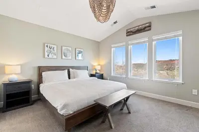 a bedroom with a bed with a bench and windows at Hillside at Horsetooth Lake & Mountain Views, Near Trails in Fort Collins