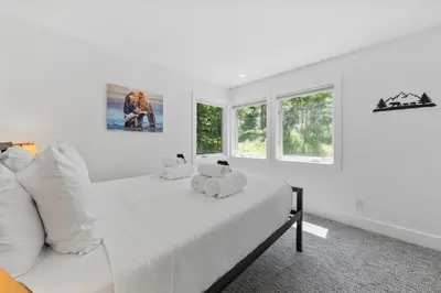 a white bedroom with a bed with two stuffed animals on it at Granby Mountain - Forest Views, Hot Tub & Fire Pit in Granby