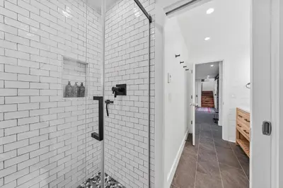 a bathroom with a shower with white brick walls at Granby Mountain - Forest Views, Hot Tub & Fire Pit in Granby
