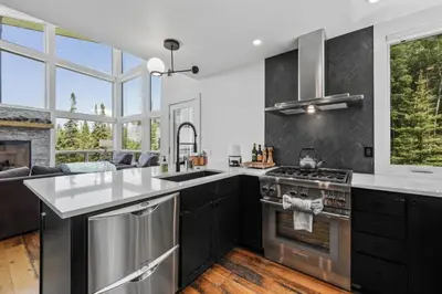 a kitchen with stainless steel appliances and a large window at Granby Mountain - Forest Views, Hot Tub & Fire Pit in Granby