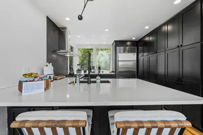 a kitchen with black cabinets and a white counter top at Granby Mountain - Forest Views, Hot Tub & Fire Pit in Granby