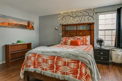 a bedroom with a large bed with orange pillows at 4 Mi to Dtwn Loveland Home with Hot Tub and Yard in Loveland