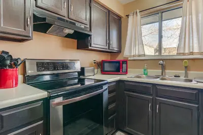 a kitchen with a stove and a microwave at 4 Mi to Dtwn Loveland Home with Hot Tub and Yard in Loveland