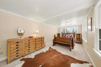 a bedroom with a bed and a dresser and a mirror at Twin Fawns cabin in Estes Park