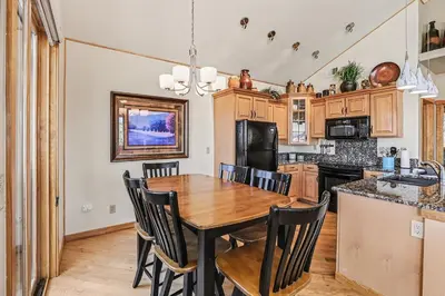a kitchen and dining room with a wooden table and chairs at Lakeview Retreat 19A condo in Estes Park