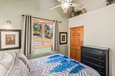 a bedroom with a bed with a dresser and a window at Lakeview Retreat 19A condo in Estes Park