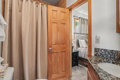 a bathroom with a sink and a wooden door at Lakeview Retreat 19A condo in Estes Park
