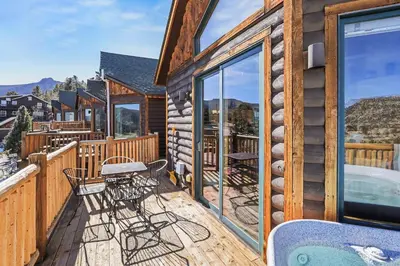 a deck with tables and chairs on a cabin at Lakeview Retreat 19A condo in Estes Park