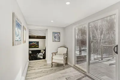 a living room with a chair and a large window at Black Hawk Getaway with Hot Tub cabin in Black Hawk