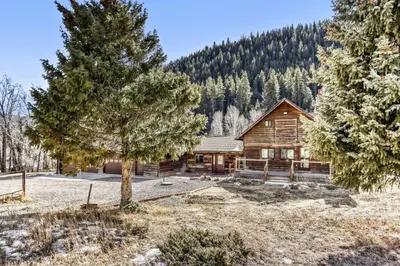 a log cabin in the mountains with a tree at Black Hawk Getaway with Hot Tub cabin in Black Hawk