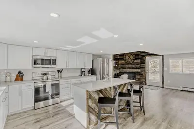 a kitchen with white cabinets and a large island at Black Hawk Getaway with Hot Tub cabin in Black Hawk