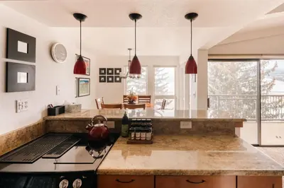 a kitchen with a counter and a stove top oven at Spacious Family Condo - Walk to Dillon Reservoir in Dillon