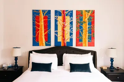 a bedroom with a bed with three paintings on the wall at Spacious Family Condo - Walk to Dillon Reservoir in Dillon