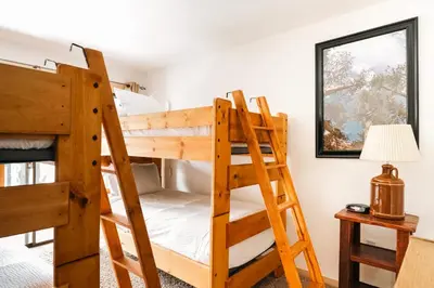 a bunk bed room with two bunk beds and a lamp at Spacious Family Condo - Walk to Dillon Reservoir in Dillon