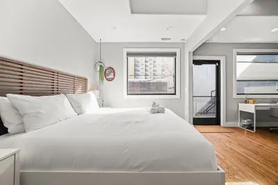 a bedroom with a large white bed and a desk at Heart of Downtown City Views Deck BBQ in Denver