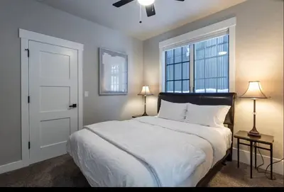 a bedroom with a large white bed with a window at Home Spa Retreat Downtown WP Walk to Shops Dining in Winter Park