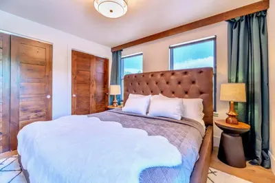 a bedroom with a large bed and two windows at Luxury Mountain Winter Getaway w Beautiful Views in Silverthorne