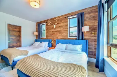 two beds in a room with two windows at Luxury Mountain Winter Getaway w Beautiful Views in Silverthorne