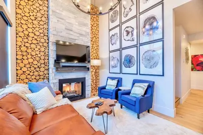 a living room with two blue chairs and a fireplace at Luxury Mountain Winter Getaway w Beautiful Views in Silverthorne
