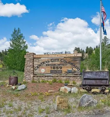 a welcome sign for a city courthouse with an american flag at Historic Mining Manor in the Colorado Rockies in Central City