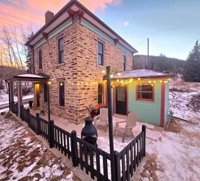 a brick house with christmas lights on it at Historic Mining Manor in the Colorado Rockies in Central City