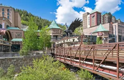 a bridge over a river in front of buildings at Historic Mining Manor in the Colorado Rockies in Central City