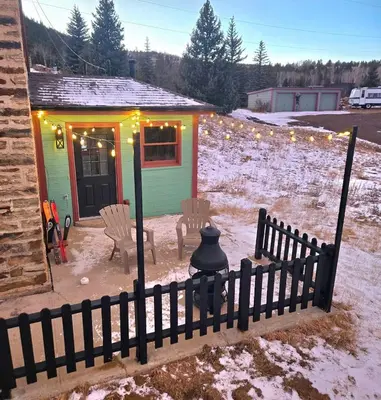 a small house with a fence in the snow at Historic Mining Manor in the Colorado Rockies in Central City