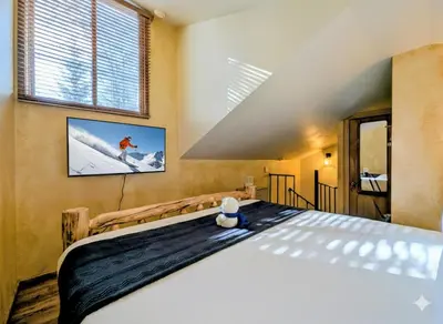 a bedroom with a large bed with a tv on the wall at Flying Dutchman 1201 by SummitCove Lodging in Keystone