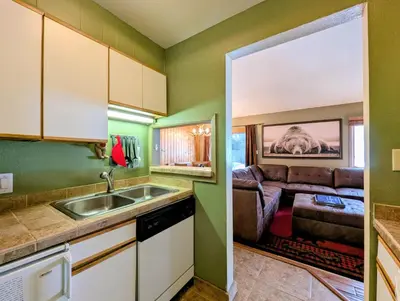 a kitchen with a sink and a couch at Flying Dutchman 1201 by SummitCove Lodging in Keystone