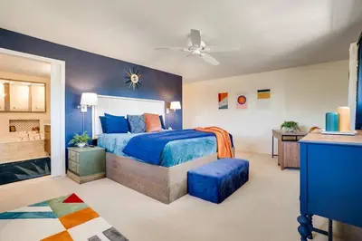 a bedroom with a blue bed and a bathroom at Mid-Century Mod - 7 BR Sleeps 22 - Hot Tub & Game Room in Westminster