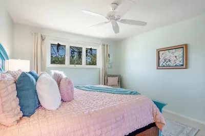 a bedroom with a bed with pillows and a ceiling fan at Mid-Century Mod - 7 BR Sleeps 22 - Hot Tub & Game Room in Westminster
