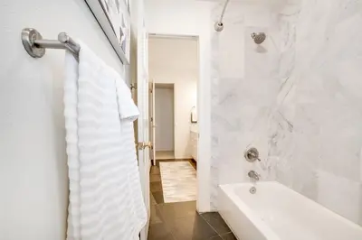 a white bathroom with a shower and a sink at Mid-Century Mod - 7 BR Sleeps 22 - Hot Tub & Game Room in Westminster