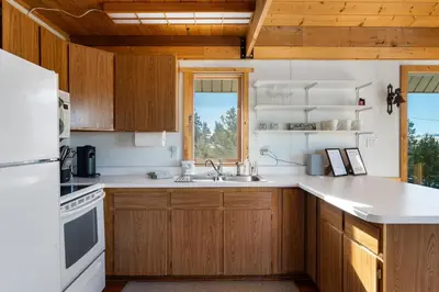 a kitchen with wooden cabinets and a sink and a window at Peaks Perch home in Granby