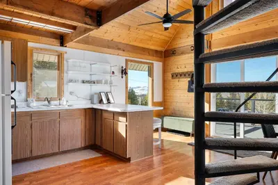 a kitchen with wooden cabinets and a ceiling fan at Peaks Perch home in Granby