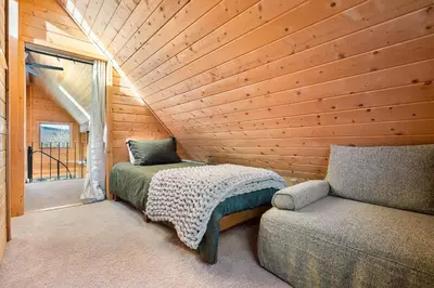 a bedroom with a bed and a couch next to a window at Peaks Perch home in Granby