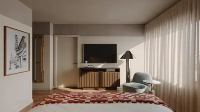 a bedroom with a bed and a tv and a chair at All Inn in Denver