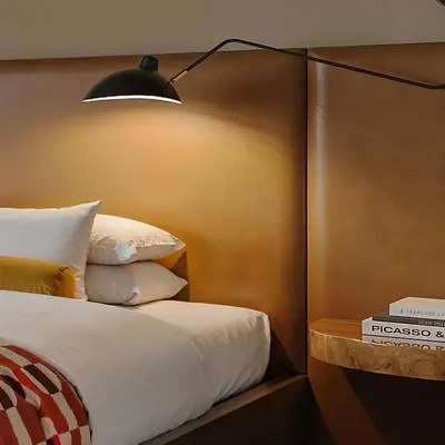 a bedroom with a bed with a lamp on it at All Inn in Denver