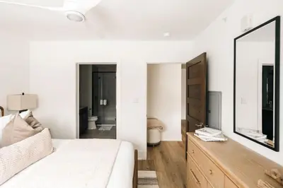 a white living room with a white couch and a mirror at Refined Riverfront Living - King Suite & Views in Silverthorne