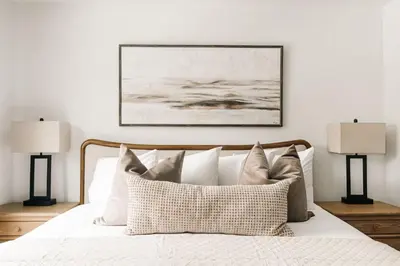 a bedroom with a white bed with two lamps at Refined Riverfront Living - King Suite & Views in Silverthorne