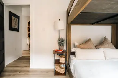 a bedroom with a white bed and a table with a lamp at Refined Riverfront Living - King Suite & Views in Silverthorne